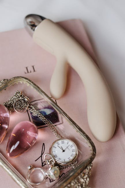 Stylish flatlay featuring vibrator, rose quartz, and jewelry for a sophisticated sensual aesthetic.